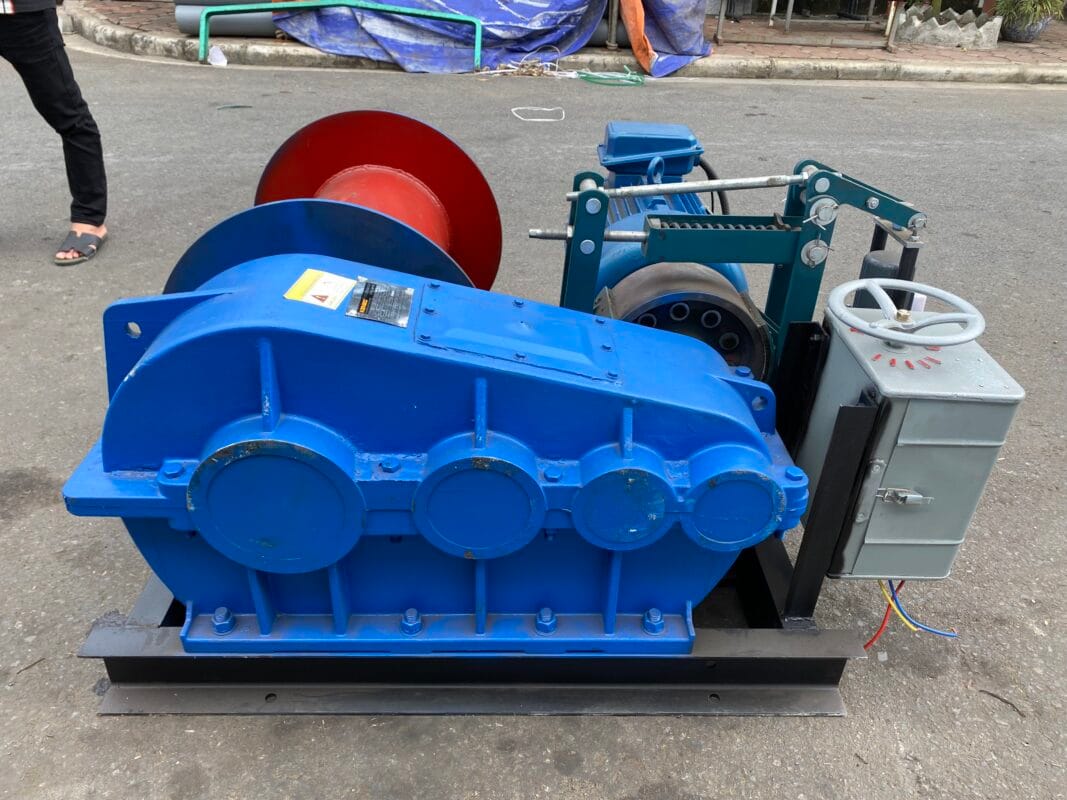 Tời Cáp Trung Quốc: Bảng Giá Mới Nhất & Kinh Nghiệm Chọn 2 Tời điện màu xanh công nghiệp đặt trên nền đường bê tông