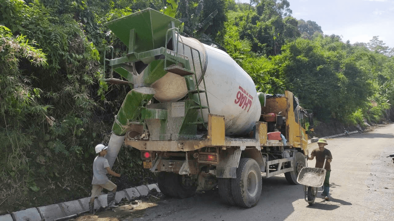 công nhân nạp vật liệu vào phễu xe bồn trộn bê tông trước khi trộn