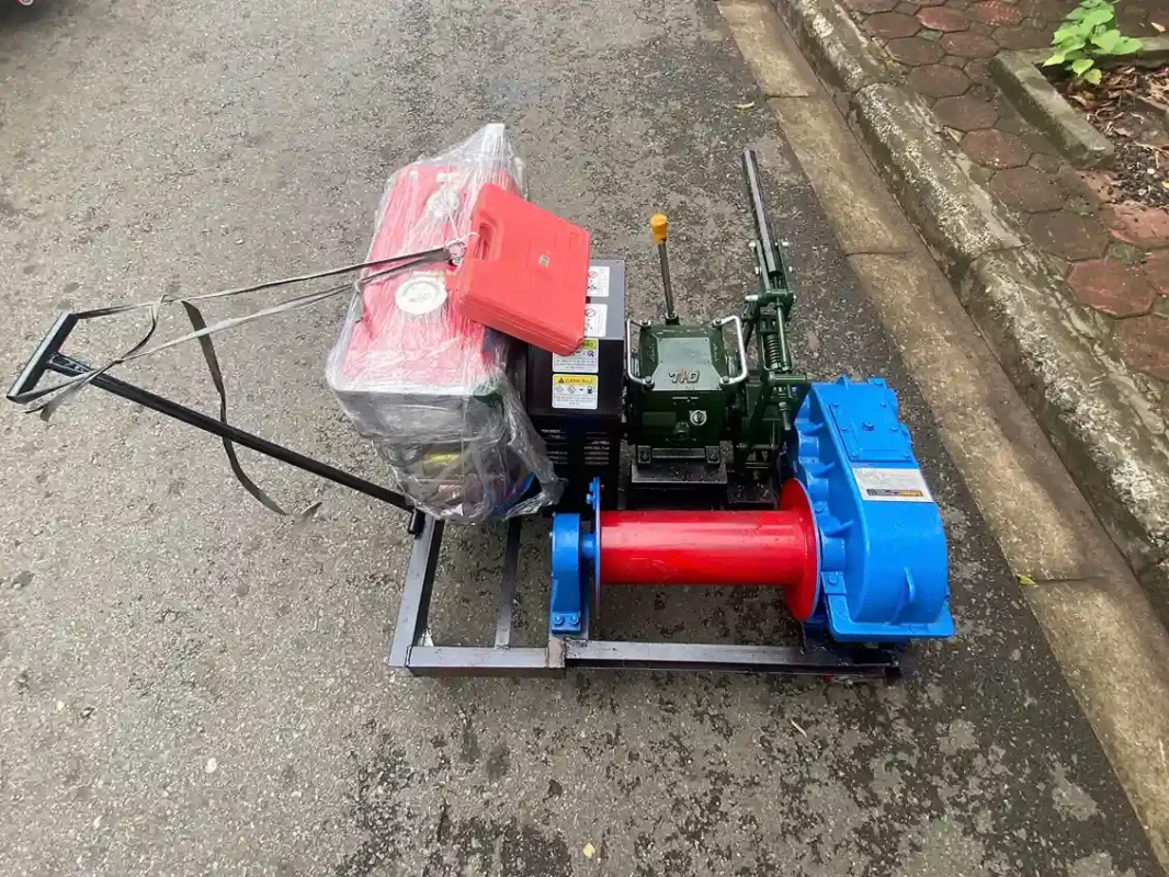 Máy tời động cơ diesel màu đỏ xanh đặt trên vỉa hè mới nguyên