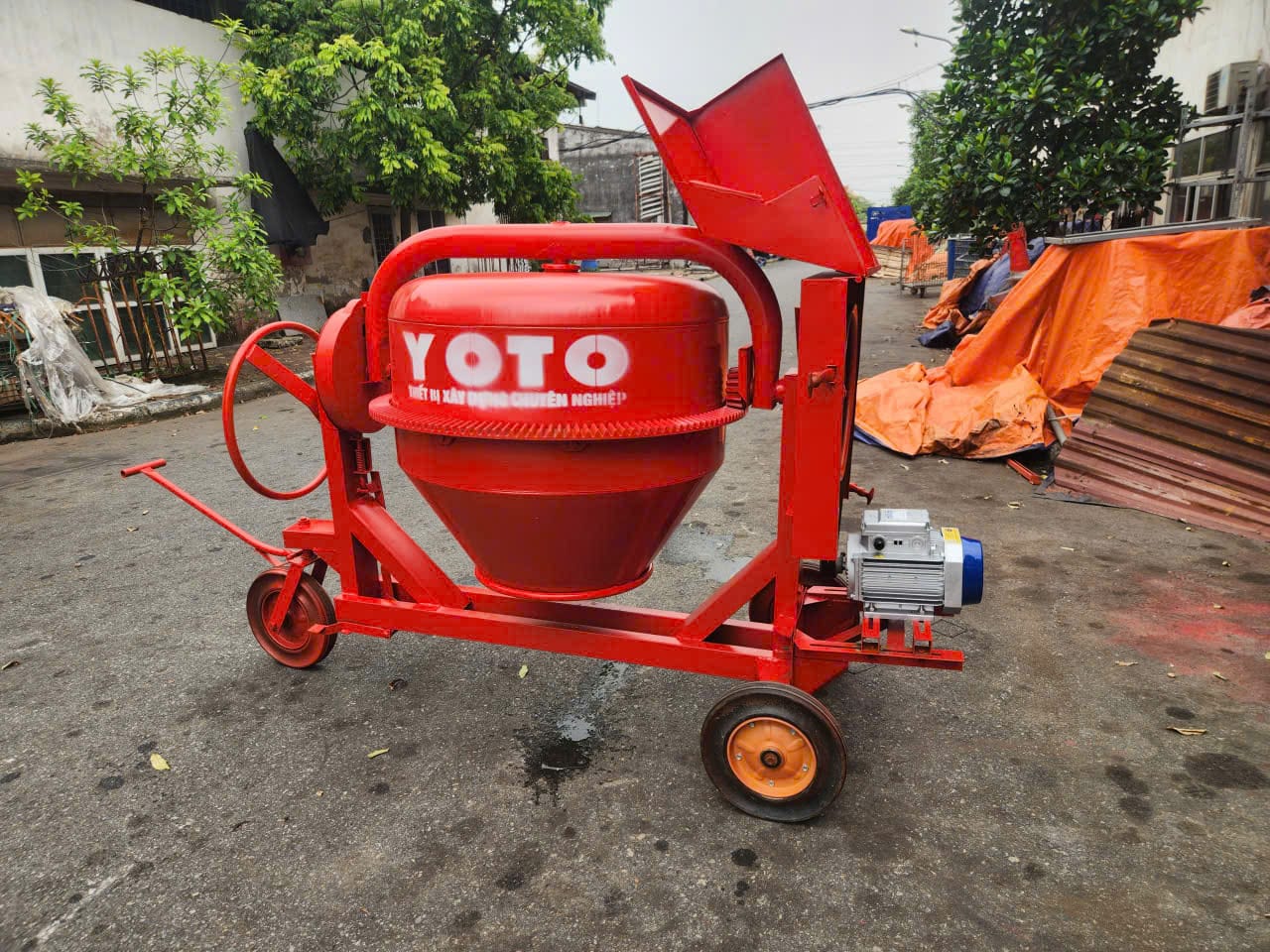 An toàn khi sử dụng máy trộn bê tông: Cơ khí, điện & vận hành 3 Máy trộn bê tông YOTO màu đỏ đặt ngoài sân công trình