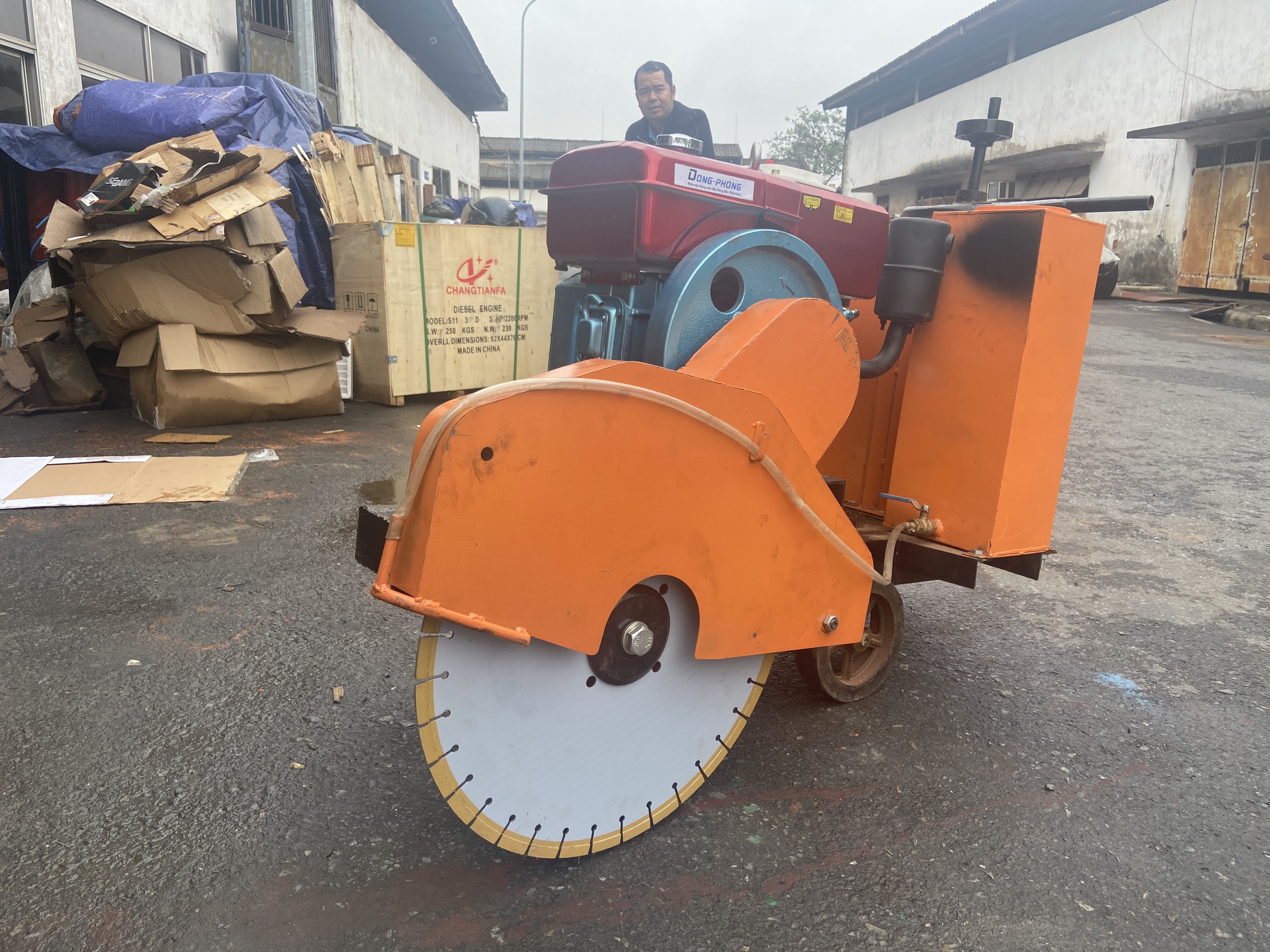 Máy cắt bê tông màu cam gắn động cơ Đông Phong với lưỡi cắt kim cương lớn